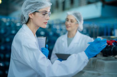 Endüstriyel fabrikadaki ters osmoz makinesinin kalitesini kontrol eden bir bilim adamı. Su deposunda veri kaydeden bir kadın işçi..