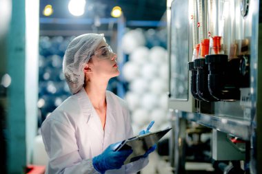 Endüstriyel fabrikadaki ters osmoz makinesinin kalitesini kontrol eden bilim adamı. Geri dönüşümlü taşınabilir fabrika için ölçü basıncıyla kontrol panelinde veri kaydeden kadın işçi.