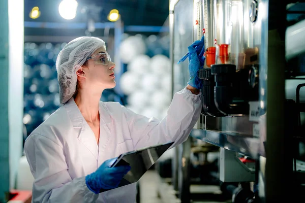科学者の労働者は 工業工場で逆浸透機械システムの品質をチェックします 制御盤にデータを記録する女性労働者で 可搬型プラントのリサイクル圧力を測定する — ストック写真