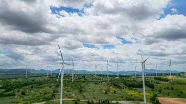 Rüzgar türbini jeneratörlerinin hava rüzgarı yel değirmeni çiftliğinde çıkarıcı enerji üretir. Gelecek ve iklim değişiklikleri için sürdürülebilir enerji kaynağı teknolojisi. Kırsal alanda yel değirmenleri inşaatı.