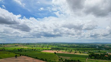 Rüzgar türbini jeneratörlerinin hava rüzgarı yel değirmeni çiftliğinde çıkarıcı enerji üretir. Gelecek ve iklim değişiklikleri için sürdürülebilir enerji kaynağı teknolojisi. Kırsal alanda yel değirmenleri inşaatı.