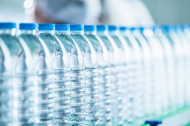 İçecek fabrikasında bir sürü maden suyu şişesi var. Üretim hattındaki temiz plastik içme suyu şişeleri..