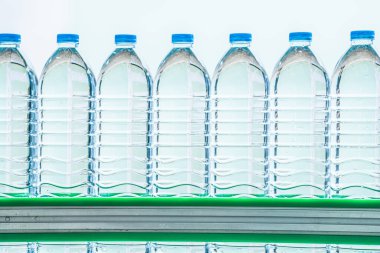 İçecek fabrikasında bir sürü maden suyu şişesi var. Üretim hattındaki temiz plastik içme suyu şişeleri..