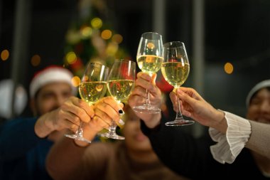 Işıklı şampanya bardaklarını kapatın. Şampanya içilen bir akşam yemeği. Eller temiz bardağı alkolle sarıda tutarken yansıtır..