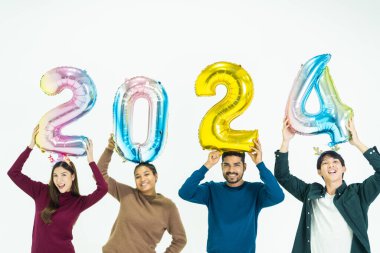 Bir grup insan yeni yıl için 2024 sayısının fantezi renkli balonlarını tutuyor. Beyaz arka planda duran kadın ve erkekler. Mutlu yıllar partisi.