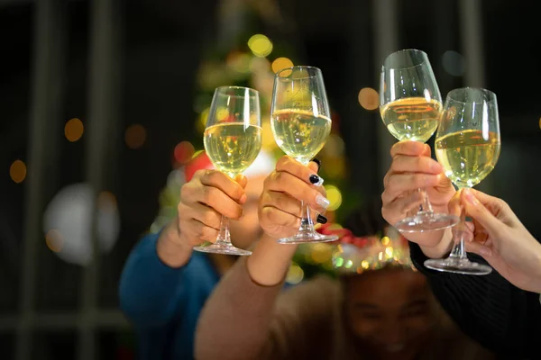 照明付きのシャンパンのメガネをクローズアップ シャンパンを飲むディナーパーティー 黄色い輝きの反射でアルコールが付いている明確なガラスを握る手 — ストック写真