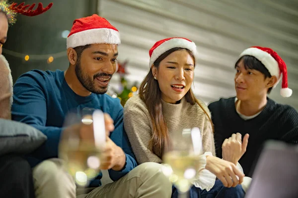 close up face of asian young teen calling through screen tablet to friends. party of people celebrating by technology online communication. friend female and male celebrating christmas at home.