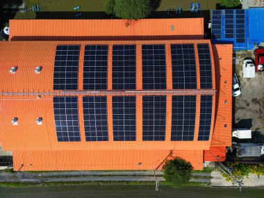 Fabrika deposunun çatısındaki güneş enerjisi sisteminin üst hava görüntüsü. Enerji ve karbon ayak izini azaltmak için fotovoltaik yenilenebilir enerji. Temiz enerji. Yapımda güneş paneli ve yapı.