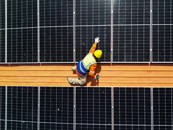 工程人员的顶层天线检查屋顶太阳能电池板或光伏电池的结构 绿色工业可再生能源 城市地区的工厂 在塔顶上工作的工人 — 图库照片