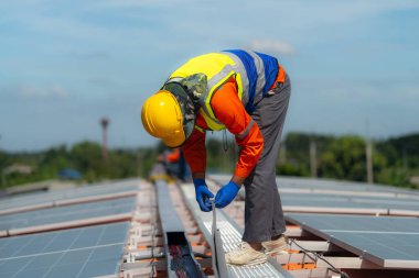 İşçi teknisyenler çatıda güneş panelleri sistemi kurmaya çalışıyorlar. Güneş fotovoltaik panel sistemi kuruluyor. Alternatif enerji ekolojik kavramı. Yenilenebilir temiz enerji teknolojisi kavramı.