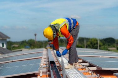 İşçi teknisyenler çatıda güneş panelleri sistemi kurmaya çalışıyorlar. Güneş fotovoltaik panel sistemi kuruluyor. Alternatif enerji ekolojik kavramı. Yenilenebilir temiz enerji teknolojisi kavramı.