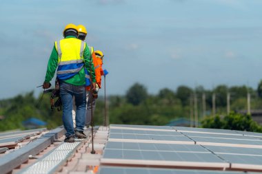 İşçi teknisyenler çatıda güneş panelleri sistemi kurmaya çalışıyorlar. Güneş fotovoltaik panel sistemi kuruluyor. Alternatif enerji ekolojik kavramı. Yenilenebilir temiz enerji teknolojisi kavramı.