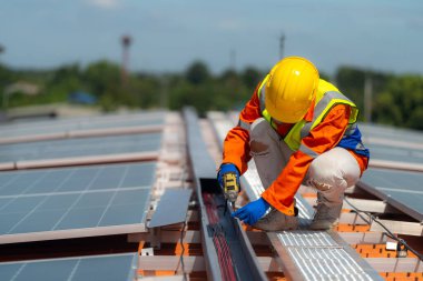 İşçi teknisyenler çatıda güneş panelleri sistemi kurmaya çalışıyorlar. Güneş fotovoltaik panel sistemi kuruluyor. Alternatif enerji ekolojik kavramı. Yenilenebilir temiz enerji teknolojisi kavramı.