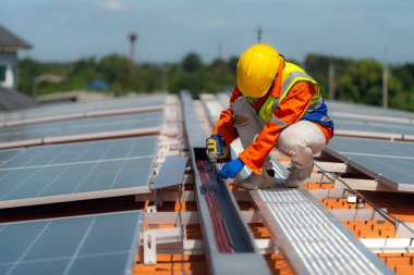 İşçi teknisyenler çatıda güneş panelleri sistemi kurmaya çalışıyorlar. Güneş fotovoltaik panel sistemi kuruluyor. Alternatif enerji ekolojik kavramı. Yenilenebilir temiz enerji teknolojisi kavramı.