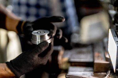 Metal Lathes için el operasyonunu kapatın. Makinede yuvarlanan çelik kolon. Metal endüstrisi. İşçi el tamirci motoru kontrol eder. Teknisyen fabrikadaki metal makinesinde matkap ucu onarıyor.