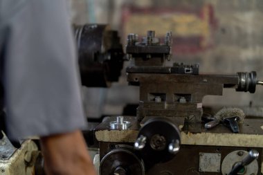 Metal Lathes için el operasyonunu kapatın. Makinede yuvarlanan çelik kolon. Metal endüstrisi. İşçi el tamirci motoru kontrol eder. Teknisyen fabrikadaki metal makinesinde matkap ucu onarıyor.