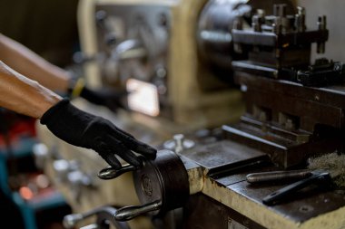 Metal Lathes için el operasyonunu kapatın. Makinede yuvarlanan çelik kolon. Metal endüstrisi. İşçi el tamirci motoru kontrol eder. Teknisyen fabrikadaki metal makinesinde matkap ucu onarıyor.