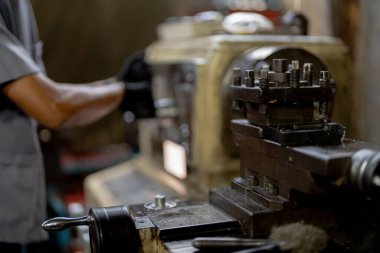Metal Lathes için el operasyonunu kapatın. Makinede yuvarlanan çelik kolon. Metal endüstrisi. İşçi el tamirci motoru kontrol eder. Teknisyen fabrikadaki metal makinesinde matkap ucu onarıyor.