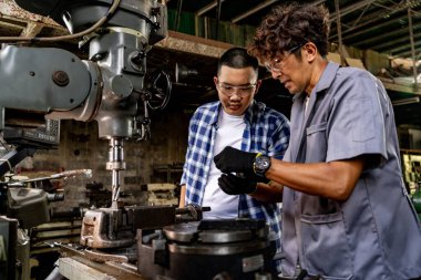 Fabrikada sondaj yapan Asyalı bir işçi. Fabrikadaki sondaj makinesinin yanında profesyonel işçi. Torna makinesinde uçan kıvılcımlarla çalışan metal iç çeliği bitirmek.