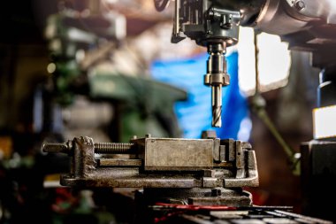 Metal matkap ucunu kapatın çelik kalıpta delikler açmak için pozisyonunuzu koruyun. Metal endüstrisi. CNC değirmen makinesinde metal plaka parçaları ile değirmen işlemi. Fabrika zemin değirmen işlemleri.
