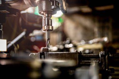 Metal matkap ucunu kapatın çelik kalıpta delikler açmak için pozisyonunuzu koruyun. Metal endüstrisi. CNC değirmen makinesinde metal plaka parçaları ile değirmen işlemi. Fabrika zemin değirmen işlemleri.