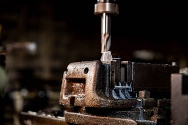 Metal matkap ucunu kapatın çelik kalıpta delikler açmak için pozisyonunuzu koruyun. Metal endüstrisi. CNC değirmen makinesinde metal plaka parçaları ile değirmen işlemi. Fabrika zemin değirmen işlemleri.