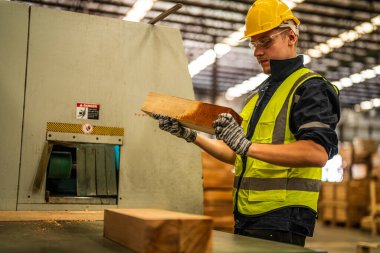 Fabrika mühendisi kereste işiyle uğraşıyor. İşçi, sanayi fabrikasındaki ağır makinede çalışıyor. Makine teçhizatı fabrika teknolojisiyle. akıllı endüstri çalışanı.