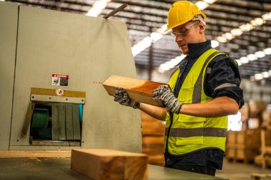 Fabrika mühendisi kereste işiyle uğraşıyor. İşçi, sanayi fabrikasındaki ağır makinede çalışıyor. Makine teçhizatı fabrika teknolojisiyle. akıllı endüstri çalışanı.