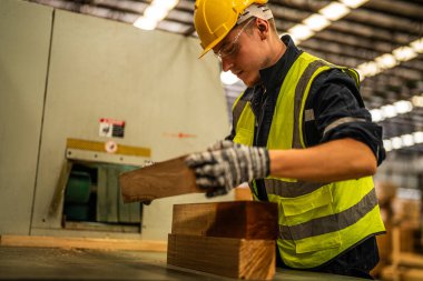 Fabrika mühendisi kereste işiyle uğraşıyor. İşçi, sanayi fabrikasındaki ağır makinede çalışıyor. Makine teçhizatı fabrika teknolojisiyle. akıllı endüstri çalışanı.