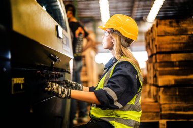 Fabrika mühendisi kadın kontrol paneli anahtarı için kendine güveniyor. İşçi, sanayi fabrikasındaki ağır makinede çalışıyor. Makine teçhizatı fabrika teknolojisiyle. akıllı endüstri çalışanı.