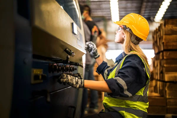 Factory engineer woman standing confidence to control panel switch. Worker works at heavy machine at industry factory. with machinery equipment plant technology. smart industry worker operating.