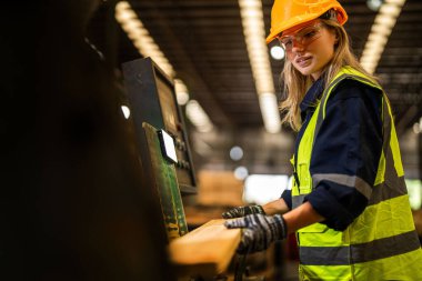 Fabrika mühendisi kadın kontrol paneli anahtarı için kendinden emin duruyor. İşçi, sanayi fabrikasındaki ağır makinede çalışıyor. İşçi, ham ahşap kerestelerini kontrol ediyor. akıllı endüstri çalışanı.