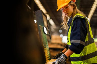 Fabrika mühendisi kadın kontrol paneli anahtarı için kendinden emin duruyor. İşçi, sanayi fabrikasındaki ağır makinede çalışıyor. İşçi, ham ahşap kerestelerini kontrol ediyor. akıllı endüstri çalışanı.