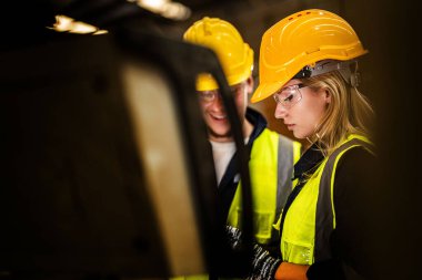 Fabrika mühendisi kadın kontrol paneli anahtarı için kendine güveniyor. İşçi, sanayi fabrikasındaki ağır makinede çalışıyor. Makine teçhizatı fabrika teknolojisiyle. akıllı endüstri çalışanı.