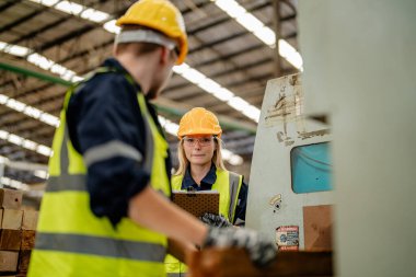 İşçi erkek ve kadın mühendisler depoda kereste odunlarını inceliyor. Akıllı endüstri çalışanı kavramı. Ahşap fabrikaları ağaç damak üretir..