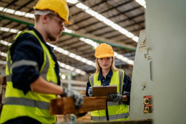 İşçi erkek ve kadın mühendisler depoda kereste odunlarını inceliyor. Akıllı endüstri çalışanı kavramı. Ahşap fabrikaları ağaç damak üretir..