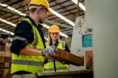 İşçi erkek ve kadın mühendisler depoda kereste odunlarını inceliyor. Akıllı endüstri çalışanı kavramı. Ahşap fabrikaları ağaç damak üretir..
