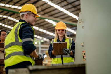 İşçi erkek ve kadın mühendisler depoda kereste odunlarını inceliyor. Akıllı endüstri çalışanı kavramı. Ahşap fabrikaları ağaç damak üretir..