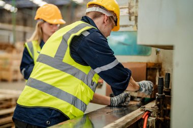 İşçi erkek ve kadın mühendisler depoda kereste odunlarını inceliyor. Akıllı endüstri çalışanı kavramı. Ahşap fabrikaları ağaç damak üretir..