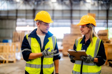 İşçi erkek ve kadın mühendisler ön makinede çalışan süit elbise ve eldiven ile yürüyorlar ve denetliyorlar. Akıllı endüstri çalışanı kavramı. Ahşap fabrikaları ağaç damak üretir..