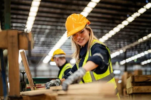 黑暗仓库行业的妇女清洁木材 车间生产中穿着安全制服 头戴硬礼帽的木匠 检查木制品质量 — 图库照片