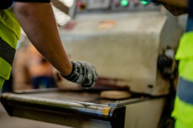 İşçi marangozlar odunları kesmek için makinelerde çalışıyorlar. Erkek ve kadın bir atölyede ahşap işçiliği yapıyorlar. Marangoz aletleri ya da elektrikli makinelerle çalışan iki usta ya da tamirci.. 