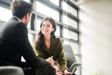 İş adamları iş yerinde eğleniyor ve sohbet ediyorlar. Erkek ve bayan meslektaşlar ortak çalışma alanında tanışmaktan hoşlanırlar. İş arkadaşlarım ofiste projeyi tartışıyorlar..