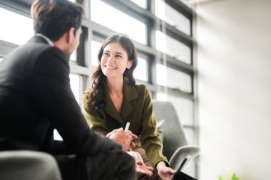İş adamları iş yerinde eğleniyor ve sohbet ediyorlar. Erkek ve bayan meslektaşlar ortak çalışma alanında tanışmaktan hoşlanırlar. İş arkadaşlarım ofiste projeyi tartışıyorlar..