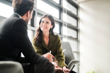 İş adamları iş yerinde eğleniyor ve sohbet ediyorlar. Erkek ve bayan meslektaşlar ortak çalışma alanında tanışmaktan hoşlanırlar. İş arkadaşlarım ofiste projeyi tartışıyorlar..