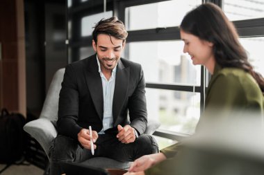 İş adamları iş yerinde eğleniyor ve sohbet ediyorlar. Erkek ve bayan meslektaşlar ortak çalışma alanında tanışmaktan hoşlanırlar. İş arkadaşlarım ofiste projeyi tartışıyorlar..