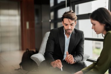 İş adamları iş yerinde eğleniyor ve sohbet ediyorlar. Erkek ve bayan meslektaşlar ortak çalışma alanında tanışmaktan hoşlanırlar. İş arkadaşlarım ofiste projeyi tartışıyorlar..