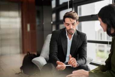 İş adamları iş yerinde eğleniyor ve sohbet ediyorlar. Erkek ve bayan meslektaşlar ortak çalışma alanında tanışmaktan hoşlanırlar. İş arkadaşlarım ofiste projeyi tartışıyorlar..