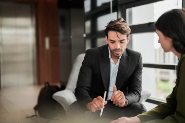 İş adamları iş yerinde eğleniyor ve sohbet ediyorlar. Erkek ve bayan meslektaşlar ortak çalışma alanında tanışmaktan hoşlanırlar. İş arkadaşlarım ofiste projeyi tartışıyorlar..