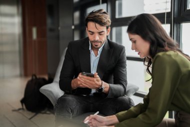 İş adamları iş yerinde eğleniyor ve sohbet ediyorlar. Erkek ve bayan meslektaşlar ortak çalışma alanında tanışmaktan hoşlanırlar. İş arkadaşlarım ofiste projeyi tartışıyorlar..